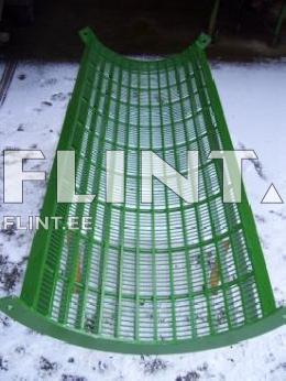 A green, curved metal grid featuring square openings, positioned on a flat surface.