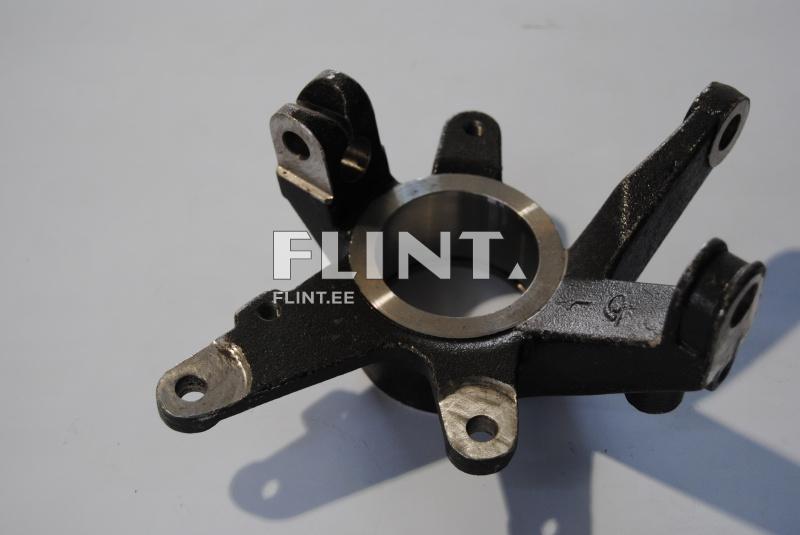 An industrial component with four extending arms and a central cylindrical metal tube. The surface is partially clean, showing signs of wear and includes holes for fastening.