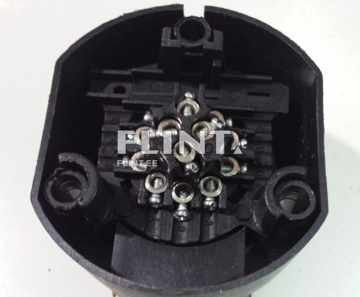 Pildil on must plastkisendi korpus, mille sees on mitmeid metallkomplekse. Keskel on rida väikesi säästikuid, mille külge on kinnitatud  tõmblukud. Korpuse ülemises osas on peal kaks avatud auku.