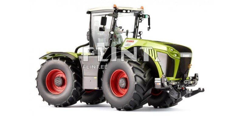 Traktor, millel on rohelised keha ja must esipaneel, punased rattad ja klaasiline kabiin. Kabiinil on mitmed juhtseadmed ning vedelemine on tõstetud kõrgusele.