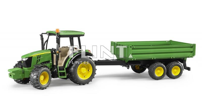The green tractor features a black cabin with a light-colored interior. It is attached to a green trailer with two yellow wheels.